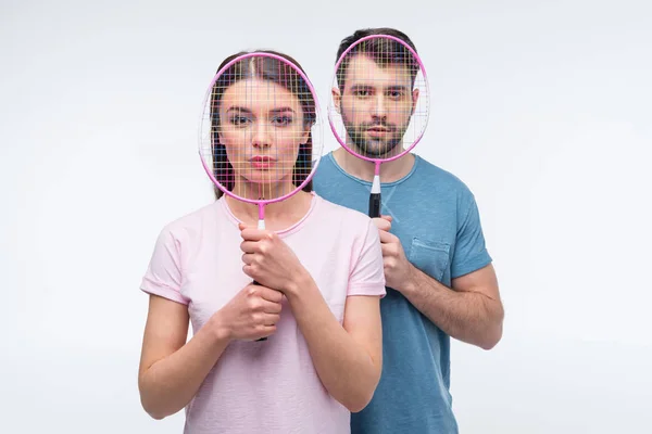 Couple with badminton rackets — Stock Photo
