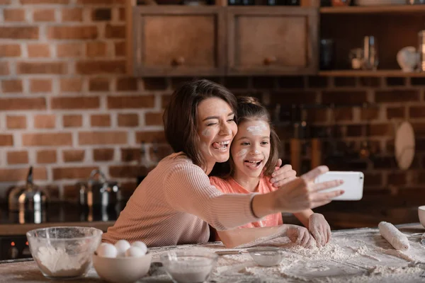 Mother and daughter in flour — Stock Photo