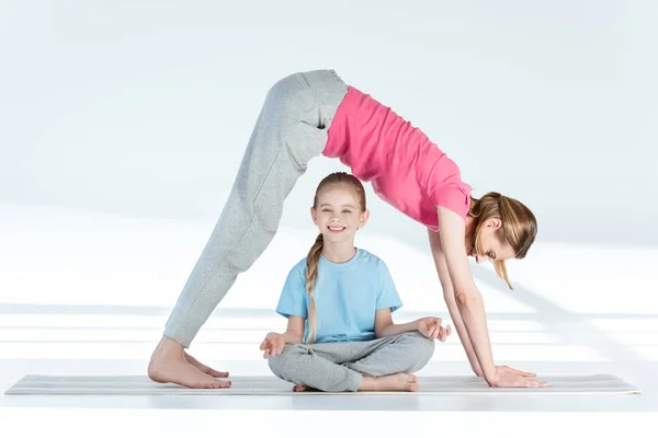 Madre e hija practicando yoga - foto de stock