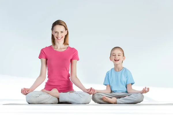 Mother and daughter in lotus position — Stock Photo