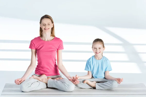 Mother and daughter in lotus position — Stock Photo