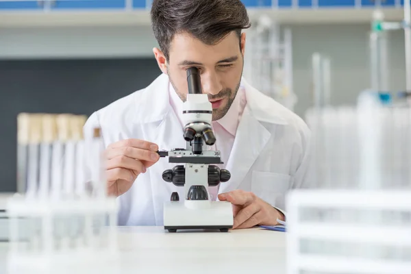 Científico trabajando con microscopio - foto de stock