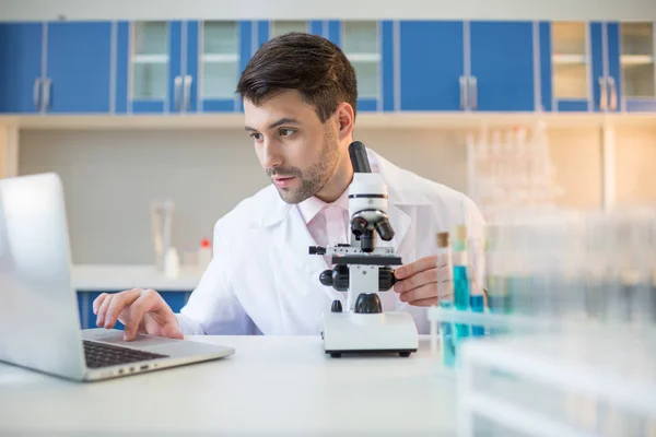 Cientista que trabalha com microscópio — Fotografia de Stock