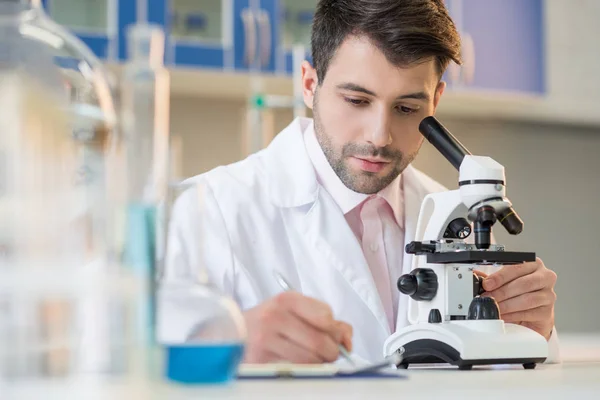 Cientista que trabalha com microscópio — Fotografia de Stock