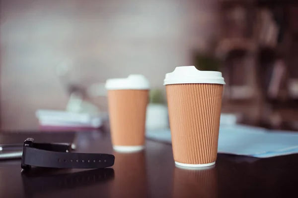 Smartwatch and coffee cups — Stock Photo