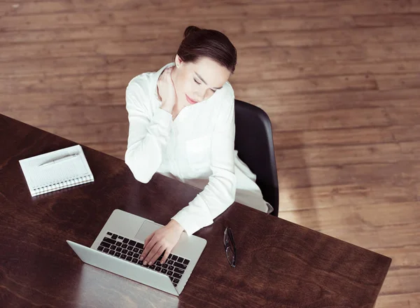 Mujer de negocios cansado utilizando el ordenador portátil - foto de stock