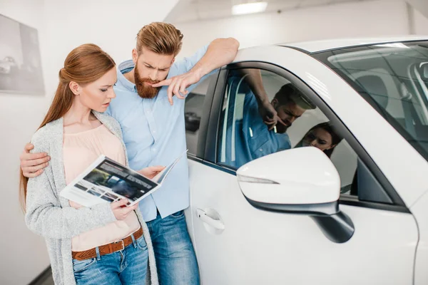 Couple in dealership salon — Stock Photo