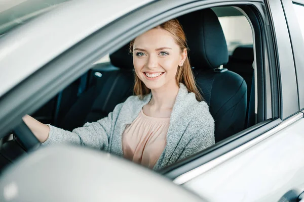 Mujer sentada en coche nuevo - foto de stock