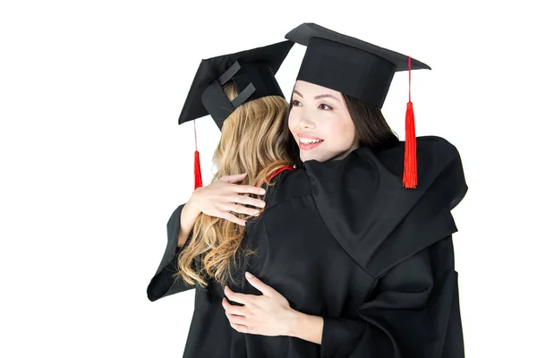 Students in graduation caps hugging — Stock Photo