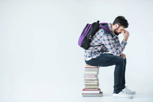 Estudante sentado em pilha de livros — Fotografia de Stock