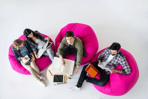 Studenti seduti su poltrone beanbag — Foto stock