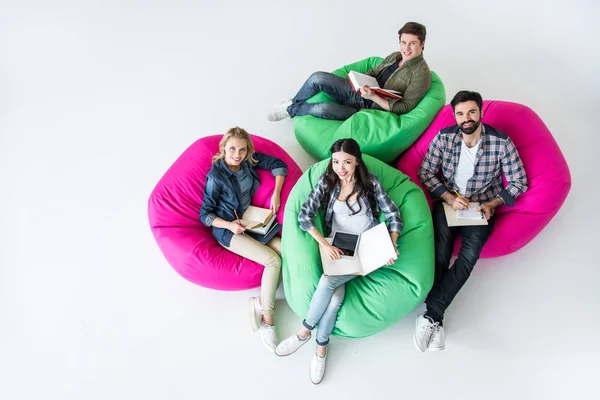 Studenti seduti su poltrone beanbag — Foto stock