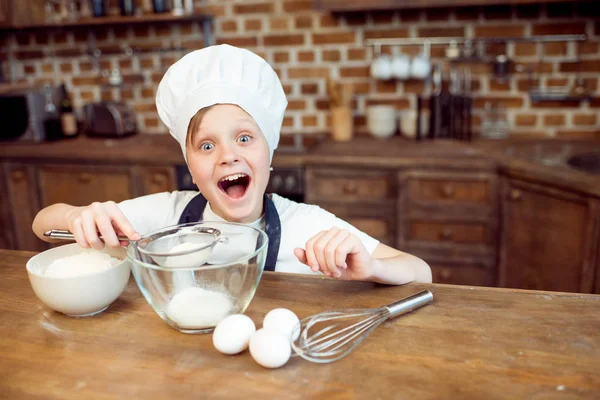 Мальчик наливает сахар в миску — стоковое фото