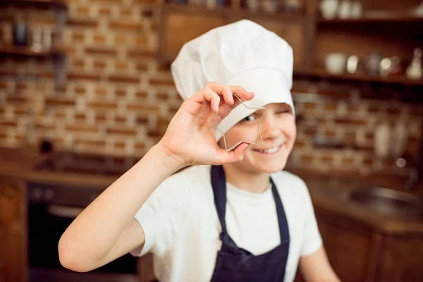 Niño sosteniendo cortador de galletas - foto de stock