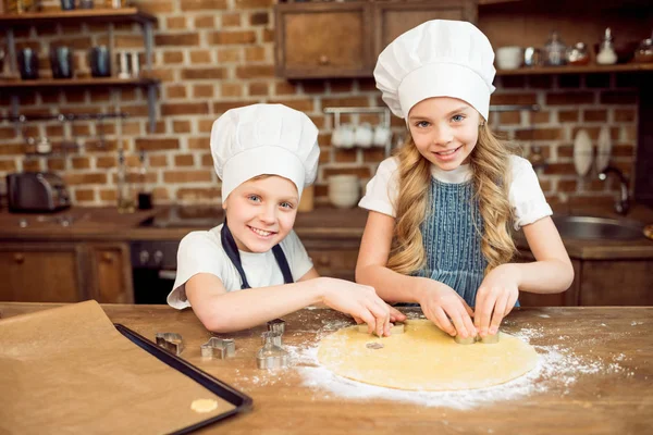 Kids making shaped cookies — Stock Photo