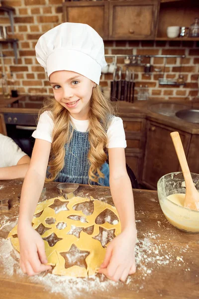 Chica haciendo galletas en forma - foto de stock
