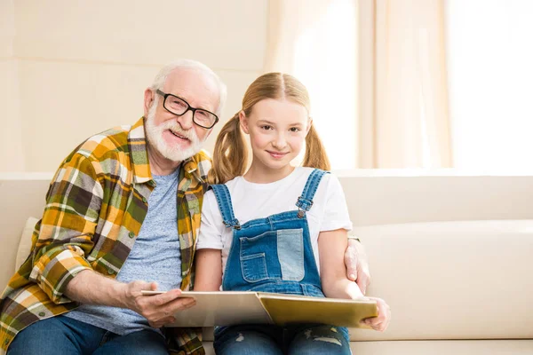 Abuelo con libro de lectura de chica - foto de stock