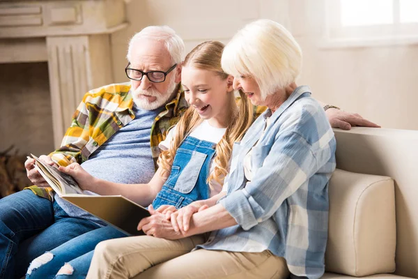 Abuelos y niños con álbum de fotos - foto de stock