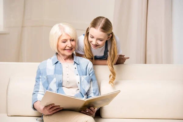 Abuela y niña con álbum de fotos - foto de stock