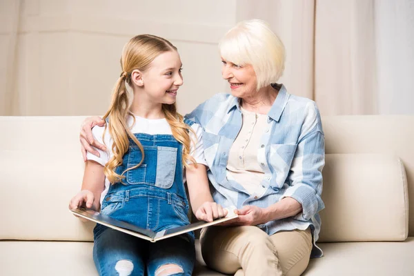 Nonna e ragazza con album fotografico — Foto stock