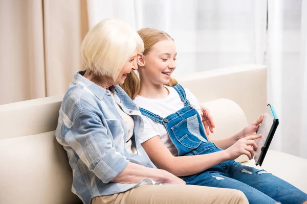 Großmutter und Mädchen mit digitalem Tablet — Stockfoto