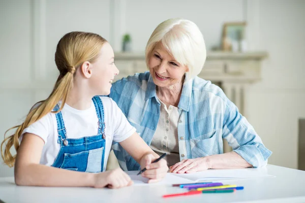 Girl with grandmother drawing — Stock Photo