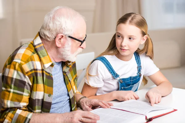 Nonno con ragazza lettura libro — Foto stock