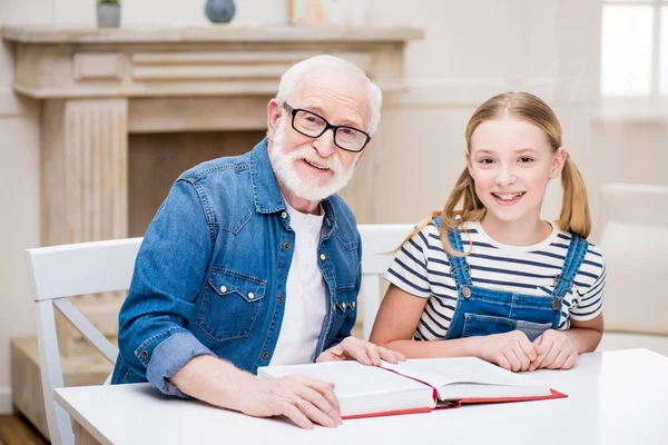 Nonno con ragazza lettura libro — Foto stock