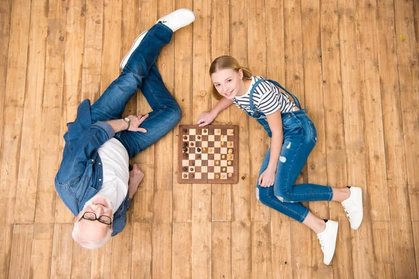 Großvater und Enkelin spielen Schach — Stockfoto