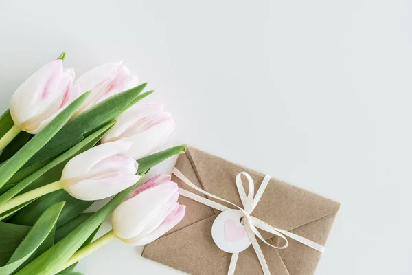 Tulipes et enveloppe rose clair — Photo de stock