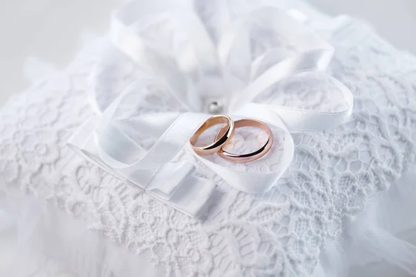 Wedding rings on lace pillow — Stock Photo