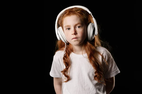 Niña en auriculares - foto de stock