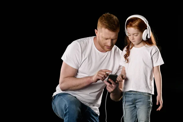 Padre e hija con dispositivos digitales - foto de stock