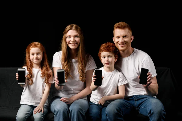 Familia mostrando smartphones - foto de stock