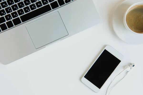 Laptop con smartphone y auriculares - foto de stock