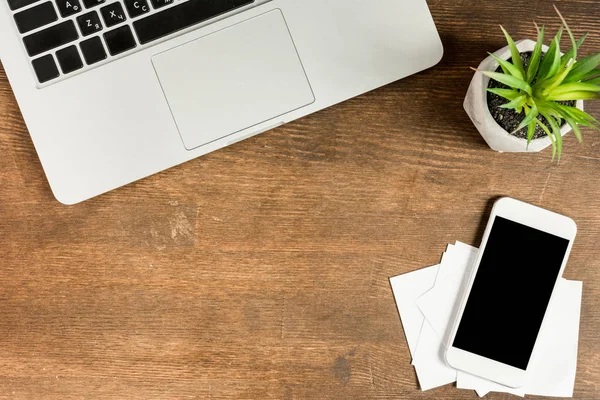 Ordenador portátil y smartphone en el lugar de trabajo - foto de stock