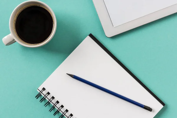 Notebook with cup of coffee and digital tablet — Stock Photo