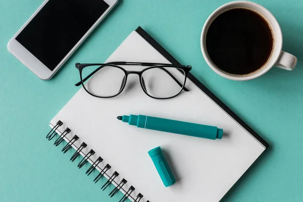 Cuaderno y smartphone en el lugar de trabajo - foto de stock