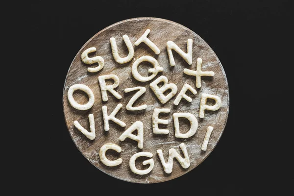 Edible letters on cutting board — Stock Photo