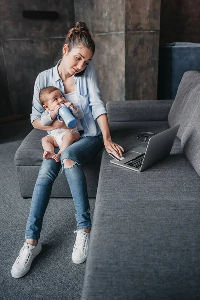 Madre con su hijo trabajando a distancia - foto de stock