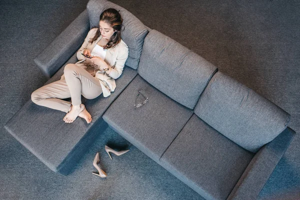 Уставшая деловая женщина отдыхает на диване — стоковое фото
