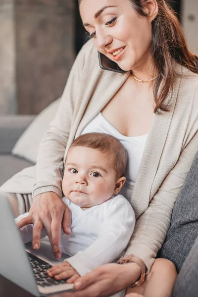 Madre con hijo usando dispositivos digitales - foto de stock