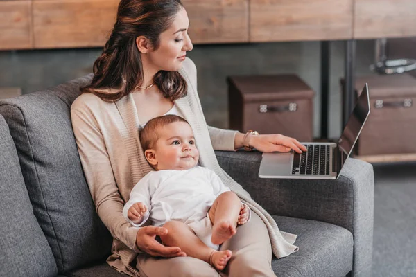Madre con hijo usando laptop - foto de stock