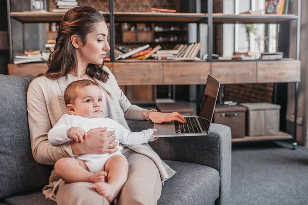 Madre con su hijo usando laptop - foto de stock