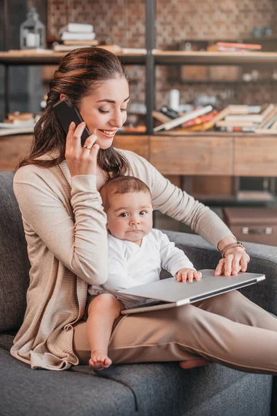 Madre con su hijo usando laptop - foto de stock