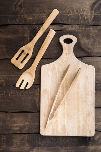 Chopping board with kitchen utensils — Stock Photo