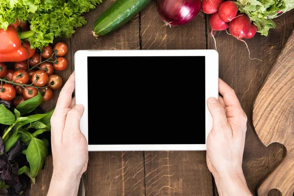 Tableta digital sobre la mesa con verduras - foto de stock