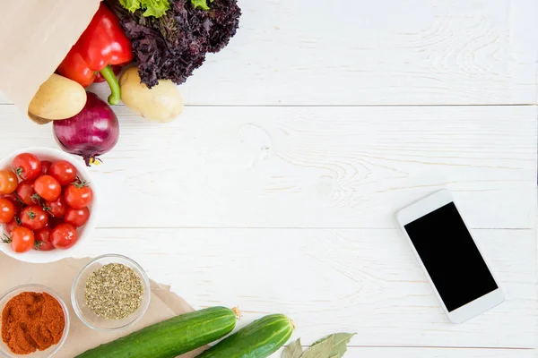 Smartphone et légumes sur la table — Photo de stock