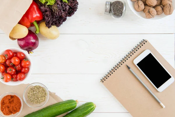 Smartphone y verduras en la mesa - foto de stock
