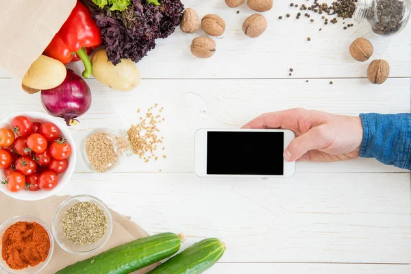 Person benutzt Smartphone beim Kochen — Stockfoto